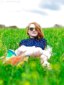 Super-Pale Ginger Lays On The Green Grass And Poses Absolutely N